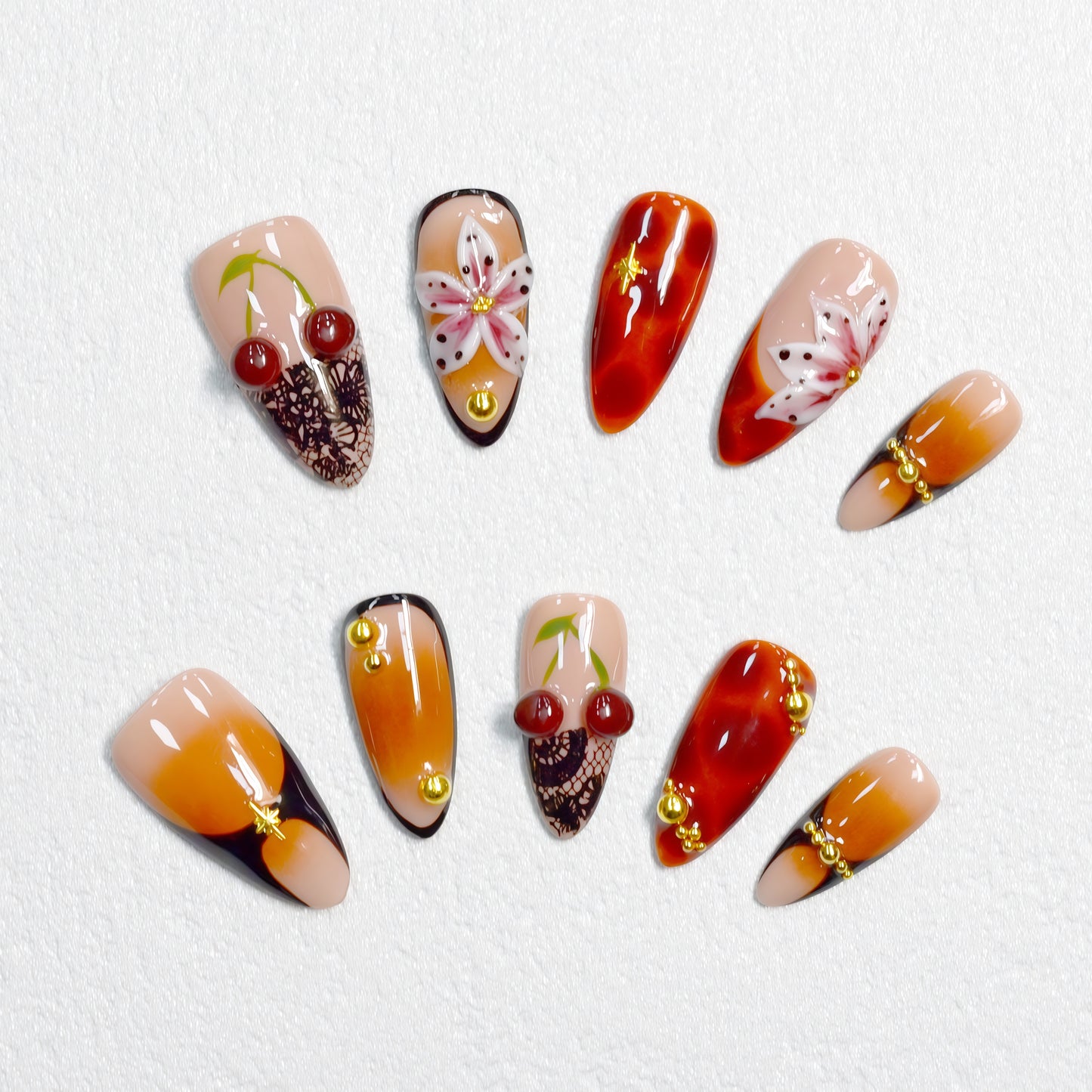 Autumn-inspired press-on nails with orange and amber tones, floral and lace details.