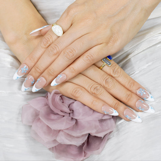 Blue Breeze almond press-on nails with French tips and small blue flower accents – Tropical Bloom Collection.