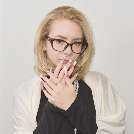 Candy Cane Spark press-on nails with red and white holiday designs, including snowflakes, hearts, and candy cane patterns.