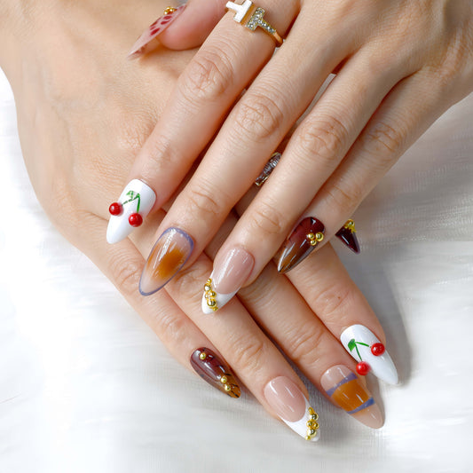 Cherry Mocha Bloom press-on nails featuring mocha brown tones, gold details, and red cherry accents with a glossy handmade finish.