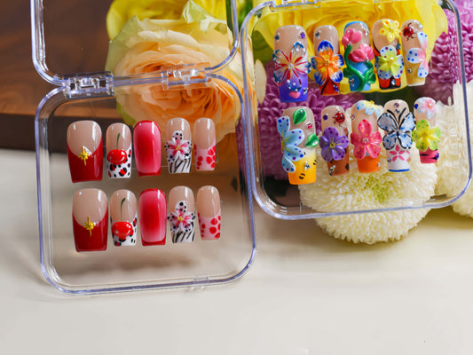 Handmade cherry-red floral press-on nails with glossy ombré finish, cherry accents, and elegant black-and-white artistic nail art