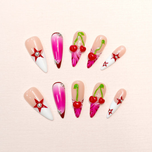 Cherry Pop Star press-on nails featuring pink ombre, 3D cherry accents, and red star details on a glossy nude base.