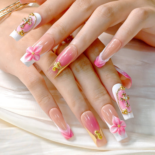 Long square press-on nails featuring coral pink ombre, gold crucifix charms, 3D pink flowers, and golden seahorse details – Coral Bloom Reverie nail set.