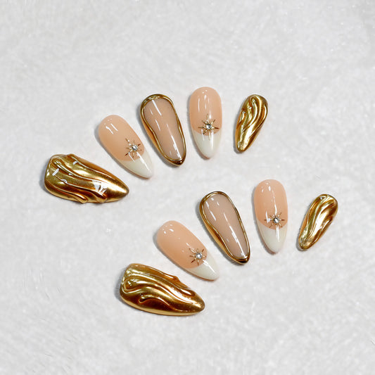 Luxury nude and gold press-on nails with chrome accents and star details. Reusable, lightweight, salon-quality nails for an elegant everyday look.