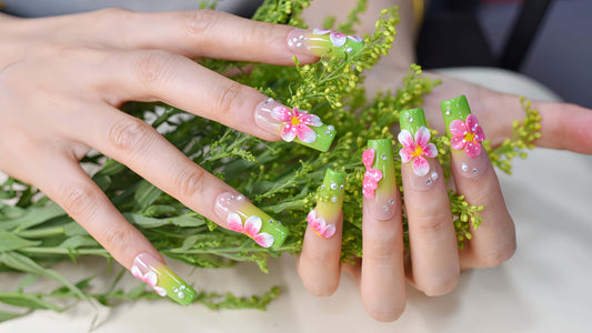 Handmade lime green floral press-on nails with 3D pink flowers and rhinestone accents on long square glossy nails