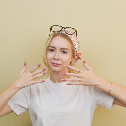 Blushing Petals press-on nails featuring pink shimmer base, 3D rose flowers, and gold accents for a soft romantic look.