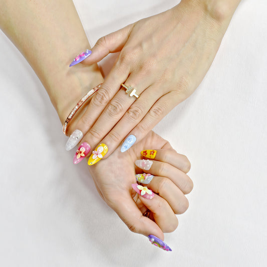 Medium almond press-on nails with bright floral 3D designs in purple, pink, yellow, and white – Petal Parade handmade nail set.