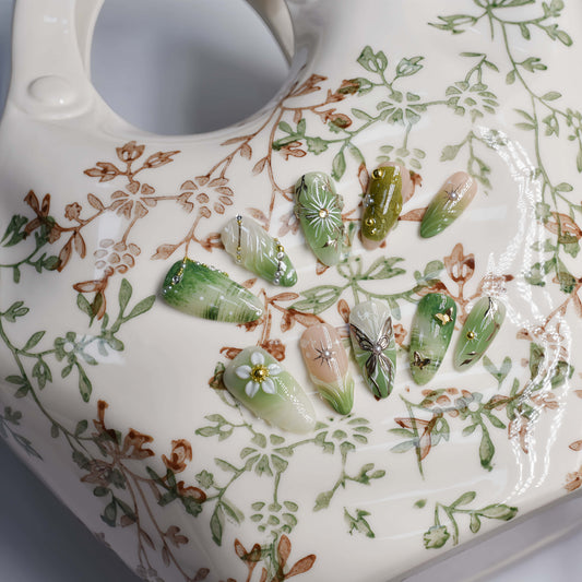 Botanical green press on nails featuring floral artwork, leaves and luxury handmade details.