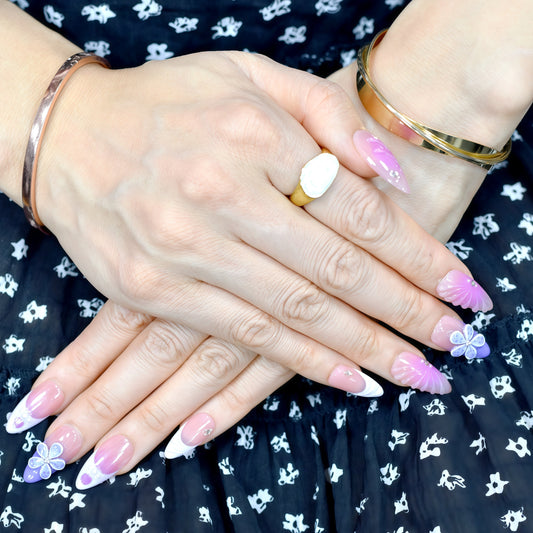 Almond-shaped press-on nails in pink-to-yellow gradient with gold beads and 3D flower accents – Sunset Bloom
