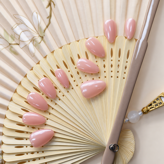 Bare Blush Veil reusable press-on nails in a sheer peach-pink nude with a glossy finish — styled product photograph.