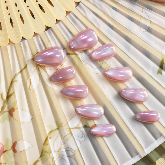 Pink Moon Chrome reusable press-on nails with a luminous blush-pink mirror finish — styled product photograph.