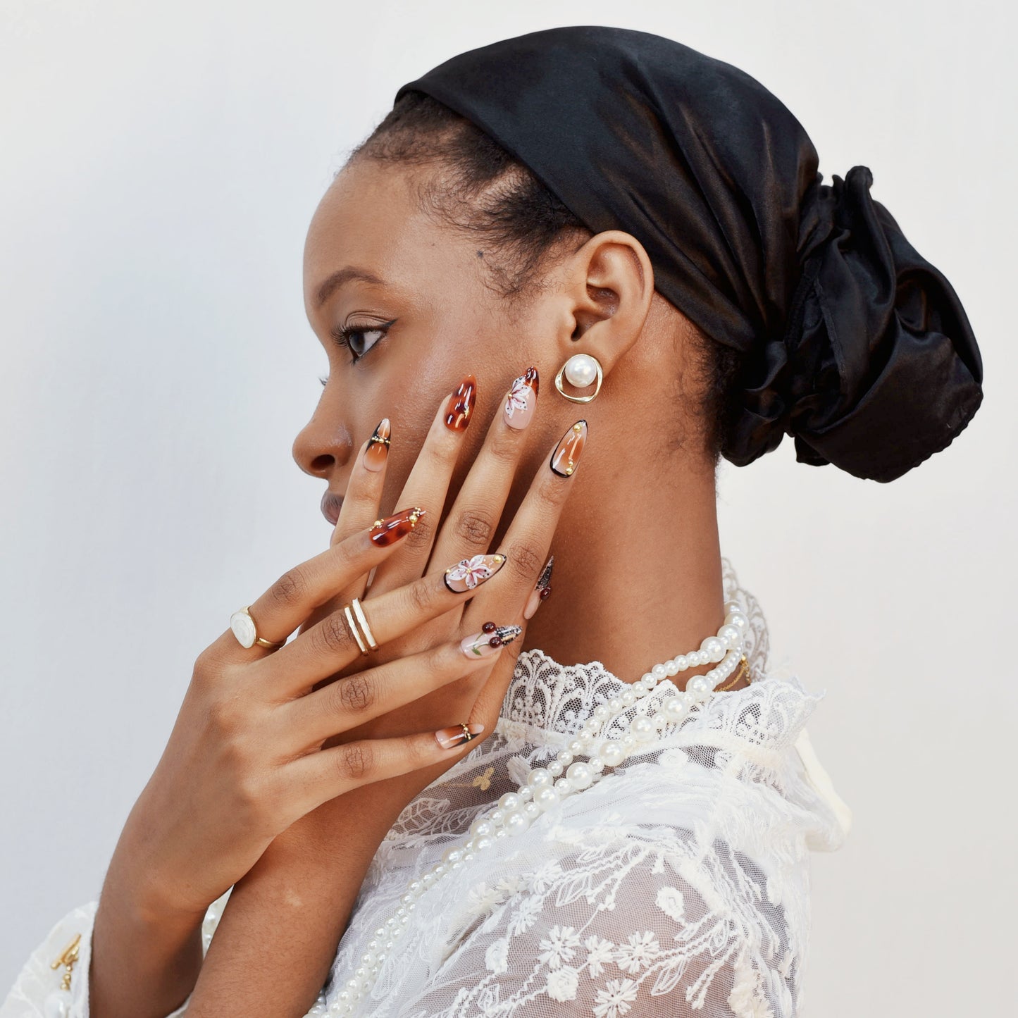 Autumn-inspired press-on nails with orange and amber tones, floral and lace details.