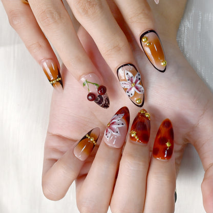 Autumn-inspired press-on nails with orange and amber tones, floral and lace details.