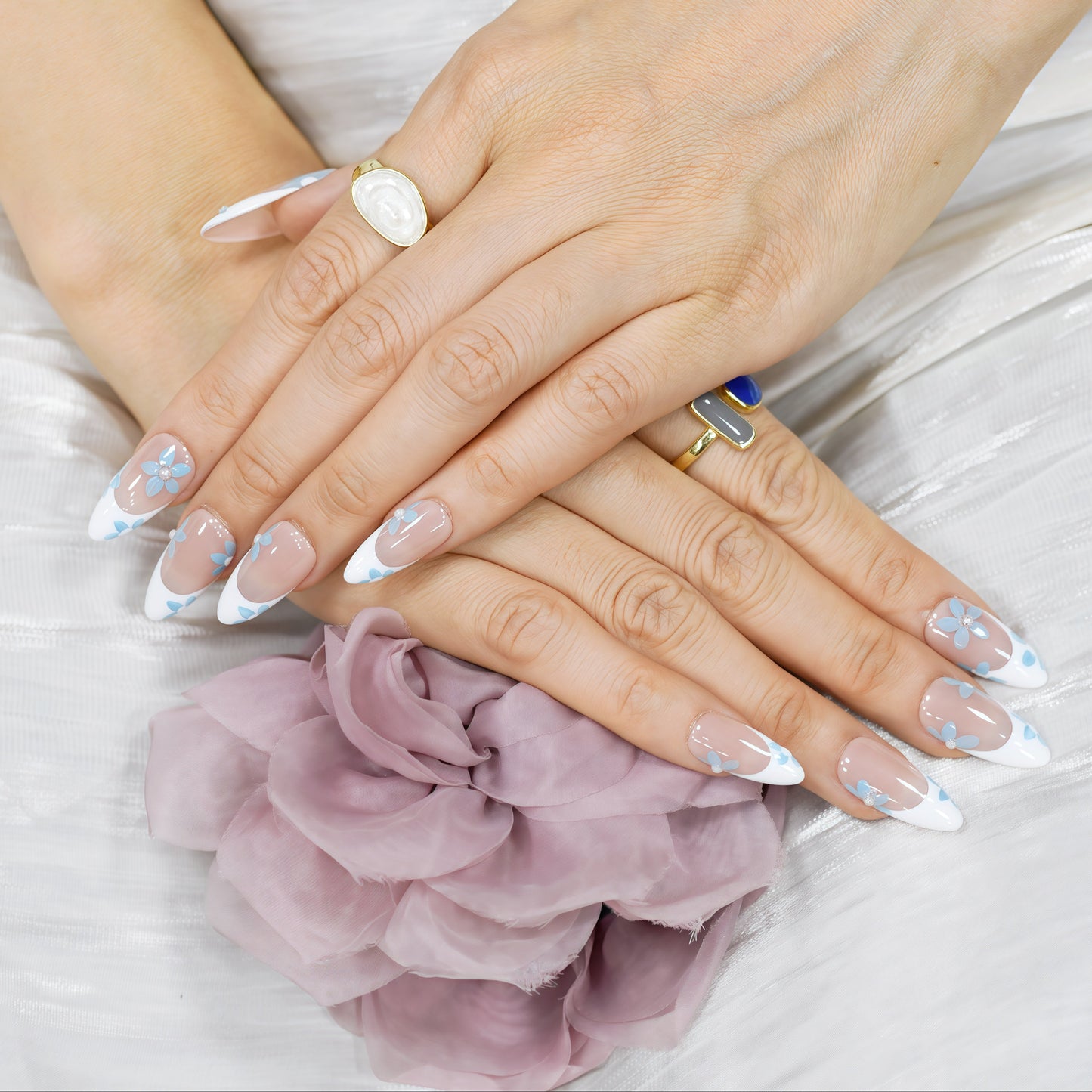 Blue Breeze almond press-on nails with French tips and small blue flower accents – Tropical Bloom Collection.