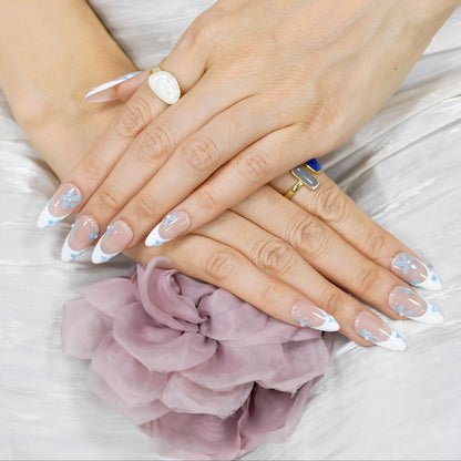Blue Breeze almond press-on nails with French tips and small blue flower accents – Tropical Bloom Collection.