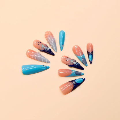 Blue Aurora press-on nails by You Are Angel with icy blue, navy, nude base, and crystal-like 3D accents.