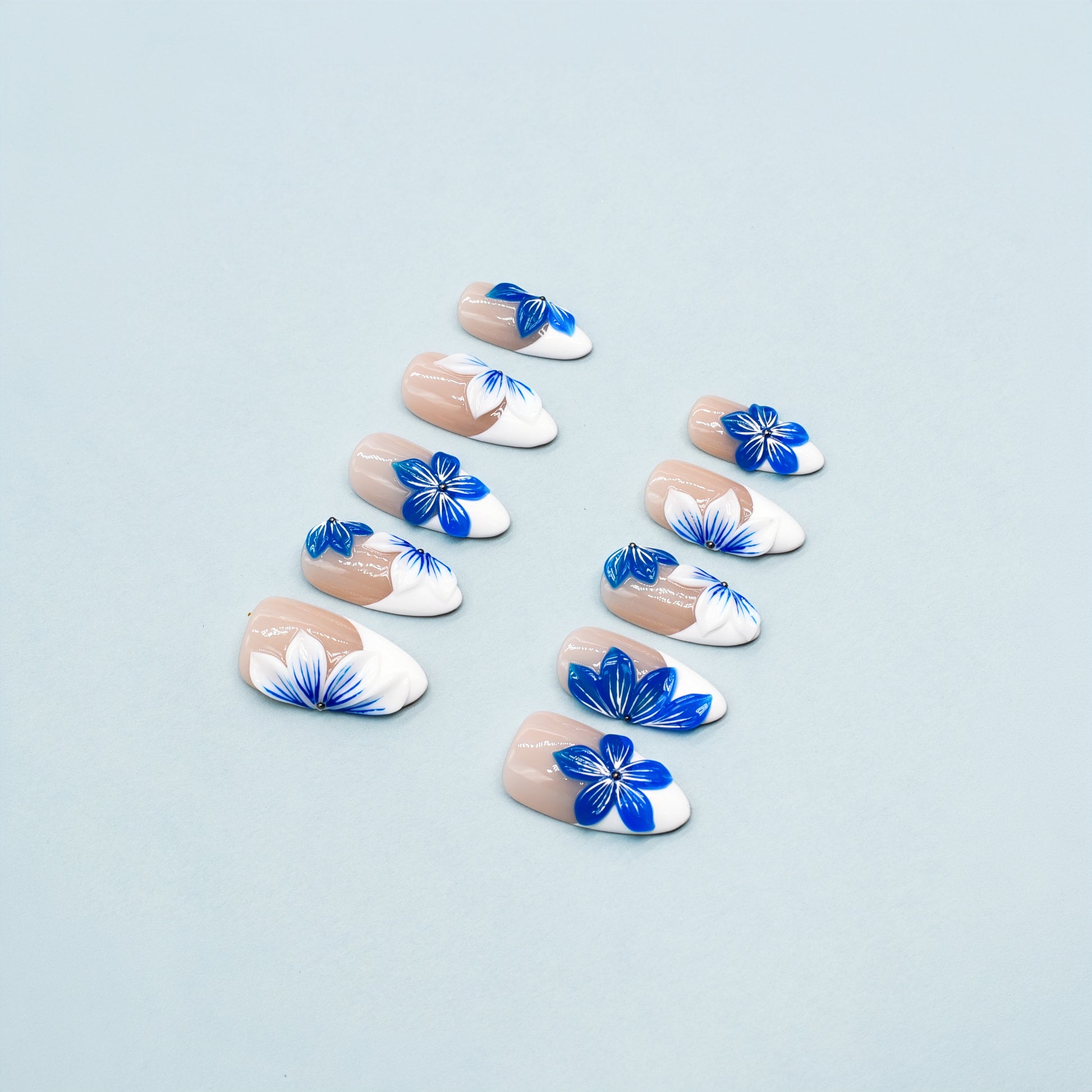 Blue Blossom almond press-on nails with French tips and vivid blue floral accents – Tropical Bloom Collection.