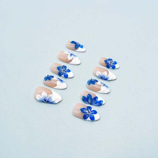 Blue Blossom almond press-on nails with French tips and vivid blue floral accents – Tropical Bloom Collection.