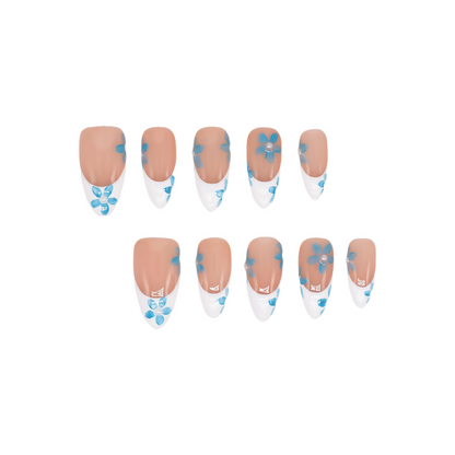 Blue Breeze almond press-on nails with French tips and small blue flower accents – Tropical Bloom Collection.