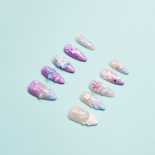 Almond-shaped pastel press-on nails with butterflies, floral art, and pearl accents – Celestial Bloom from You Are Angel.