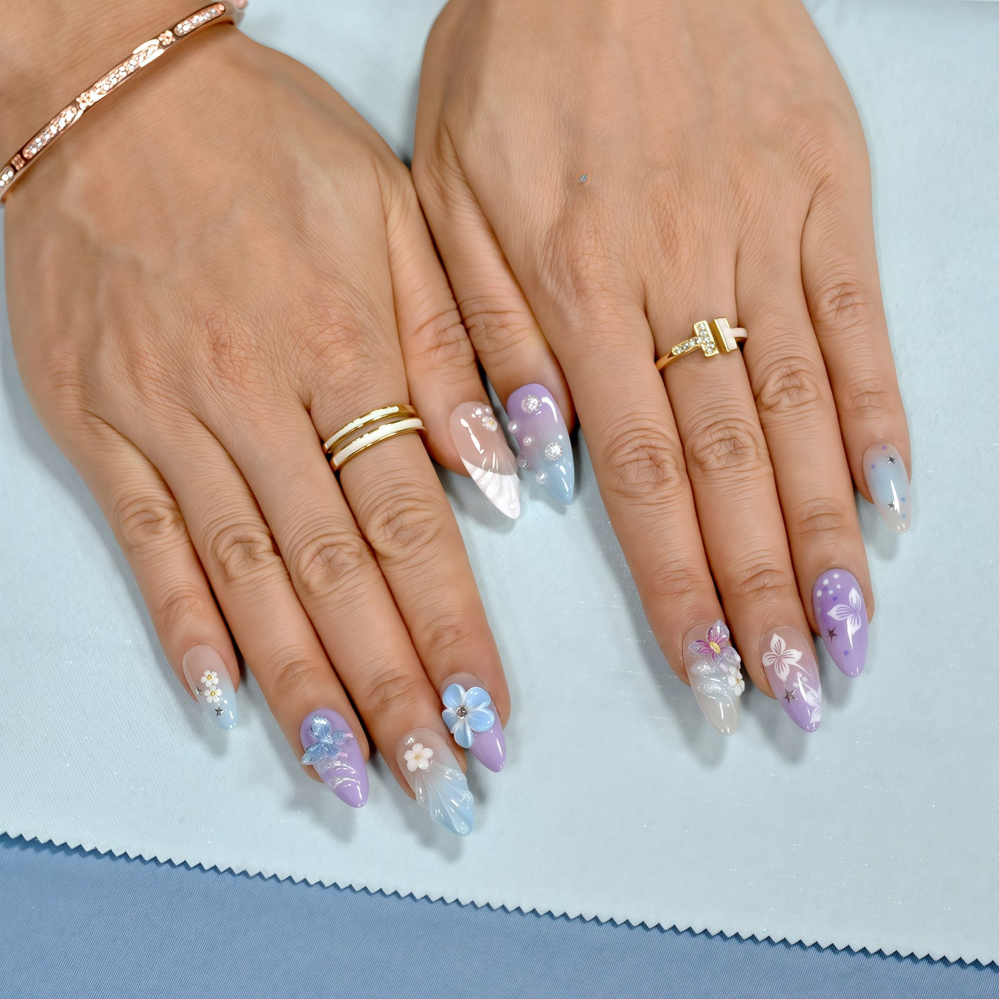 Almond-shaped pastel press-on nails with butterflies, floral art, and pearl accents – Celestial Bloom from You Are Angel.