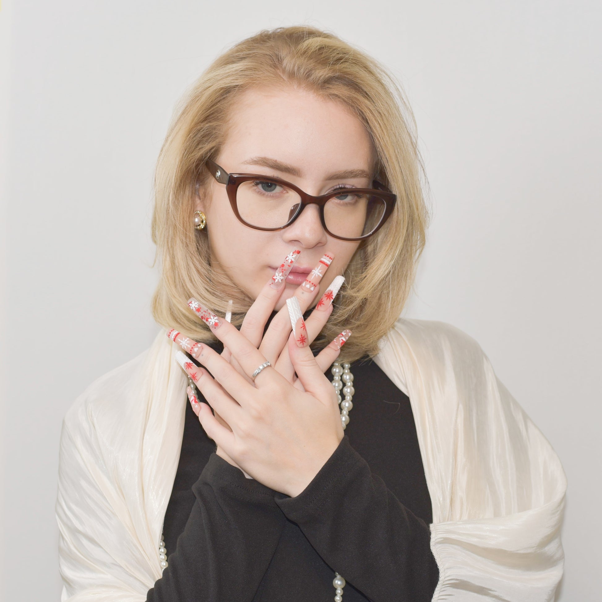 Candy Cane Spark press-on nails with red and white holiday designs, including snowflakes, hearts, and candy cane patterns.
