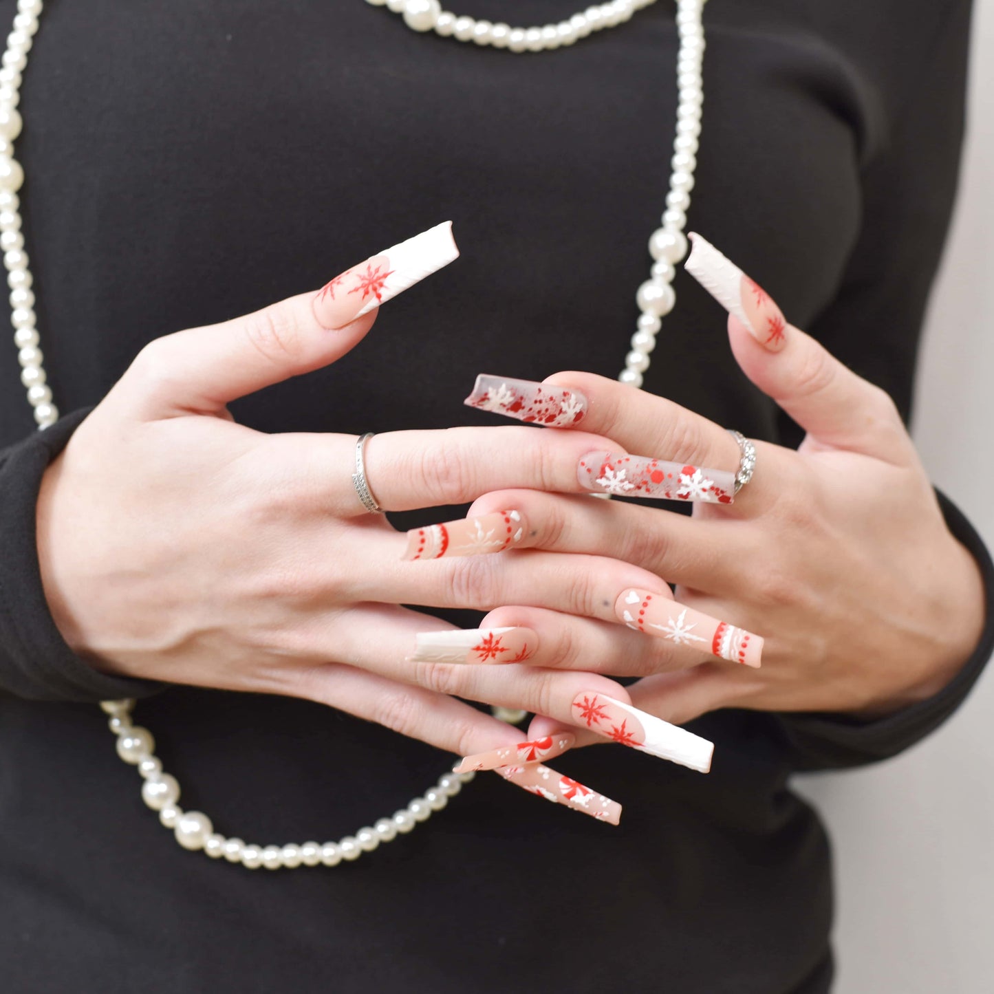 Candy Cane Spark press-on nails with red and white holiday designs, including snowflakes, hearts, and candy cane patterns.