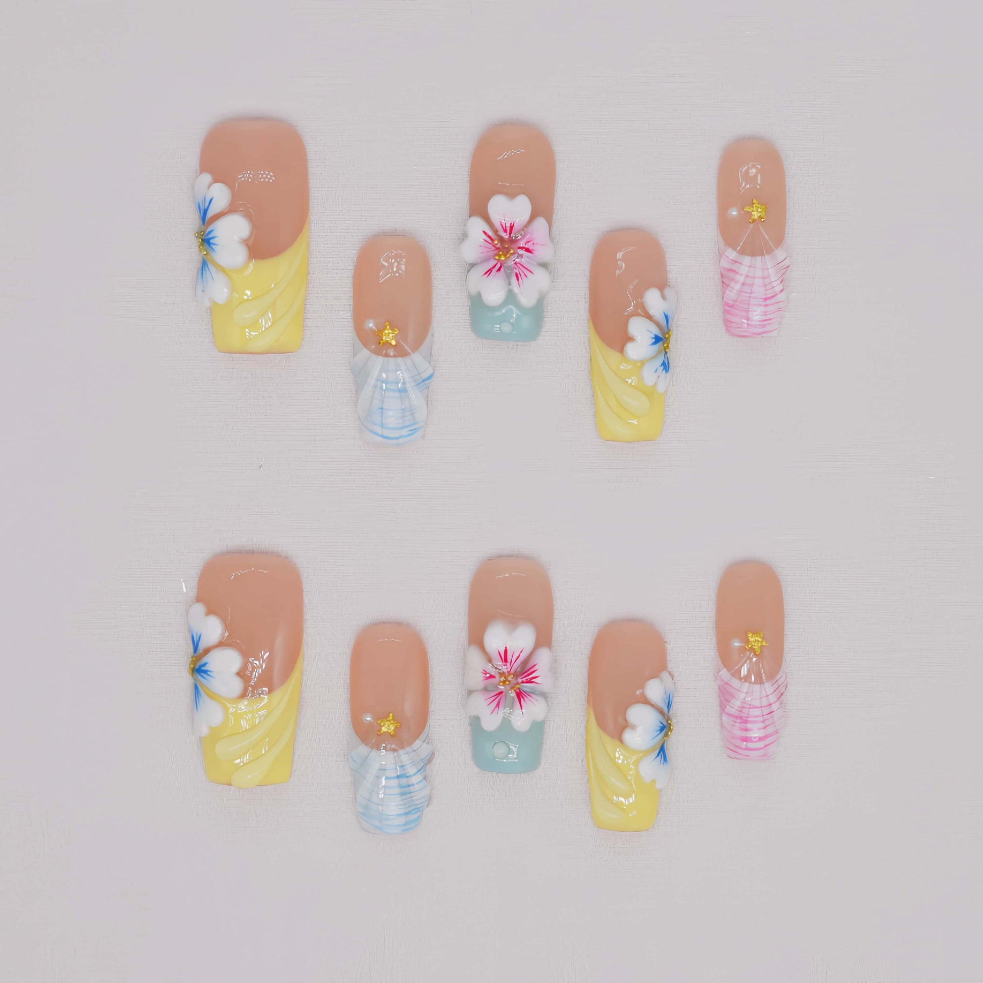Handmade pastel floral press-on nails with 3D flower art, glossy sculpted details, and soft spring-inspired colors