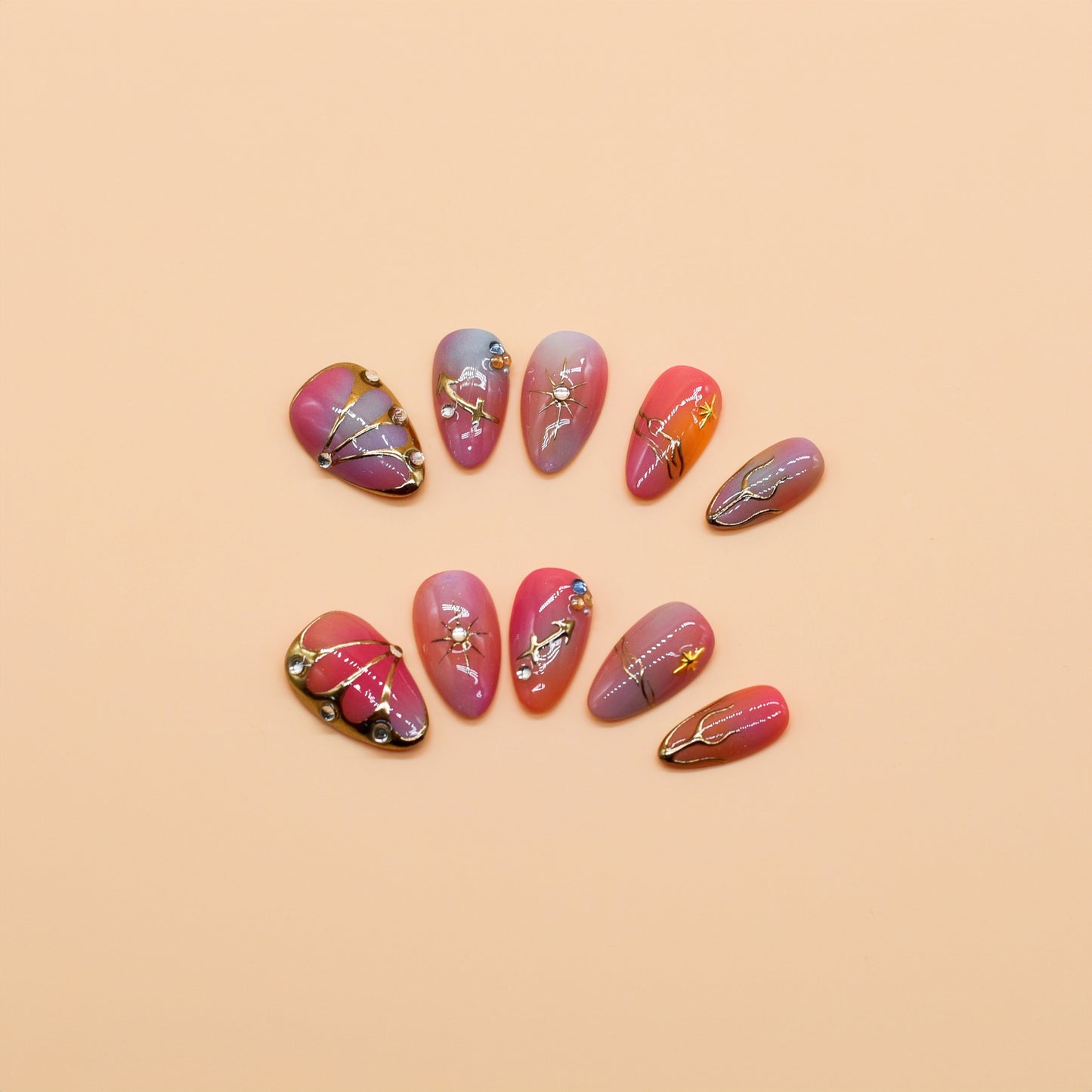 Gradient pink to purple press-on nails with celestial gold details, charms, and gemstone accents – Celestial Bloom almond-shaped handmade nail set.