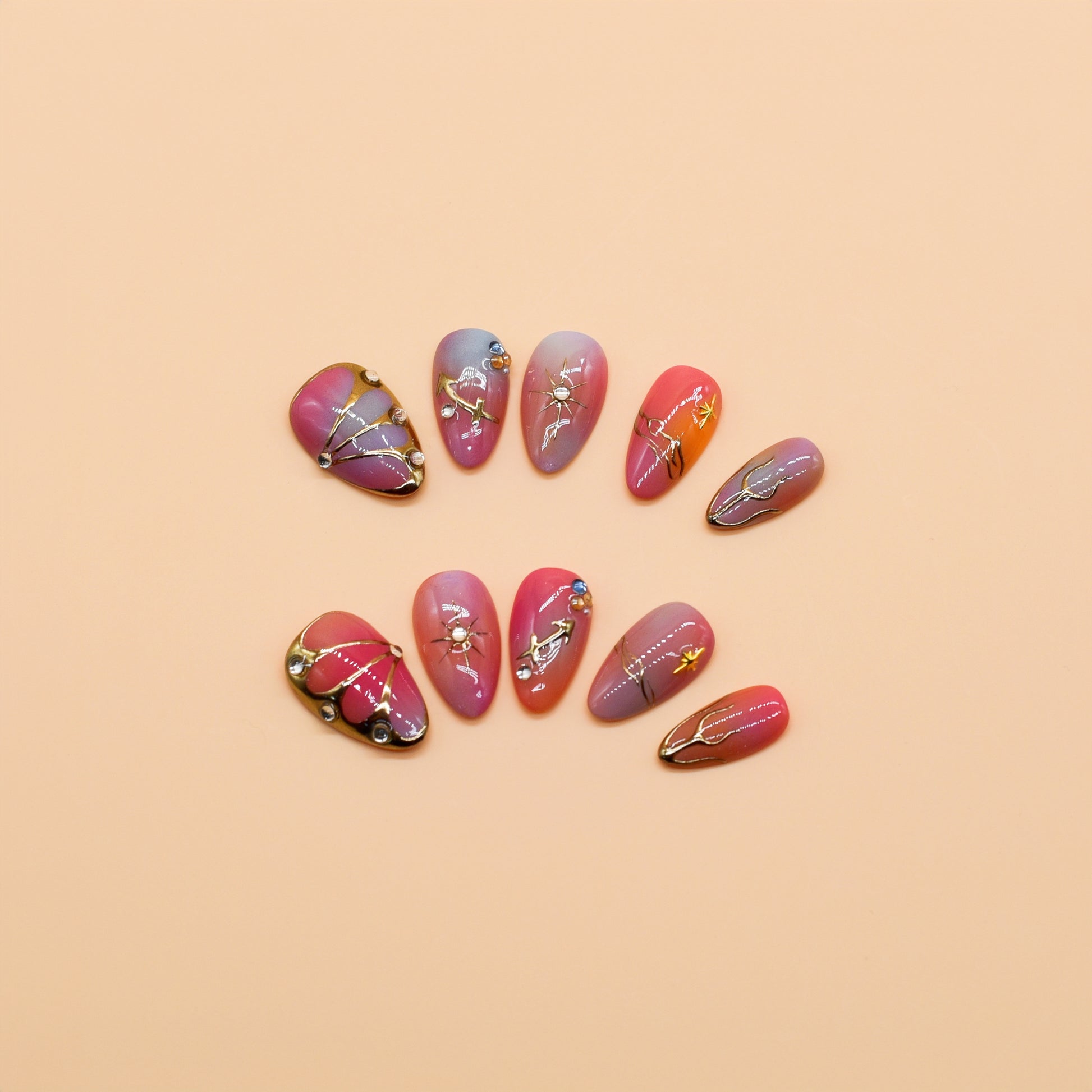 Gradient pink to purple press-on nails with celestial gold details, charms, and gemstone accents – Celestial Bloom almond-shaped handmade nail set.