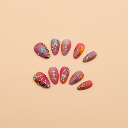 Gradient pink to purple press-on nails with celestial gold details, charms, and gemstone accents – Celestial Bloom almond-shaped handmade nail set.