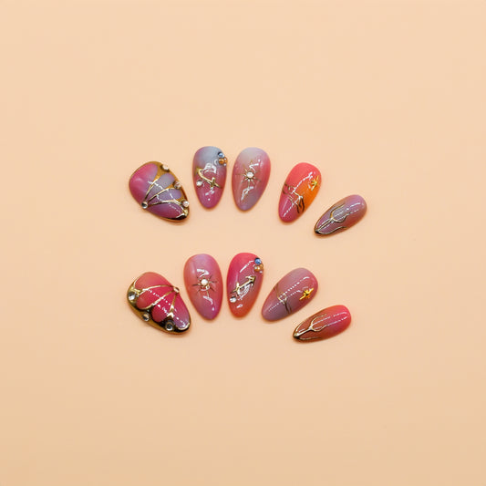 Gradient pink to purple press-on nails with celestial gold details, charms, and gemstone accents – Celestial Bloom almond-shaped handmade nail set.