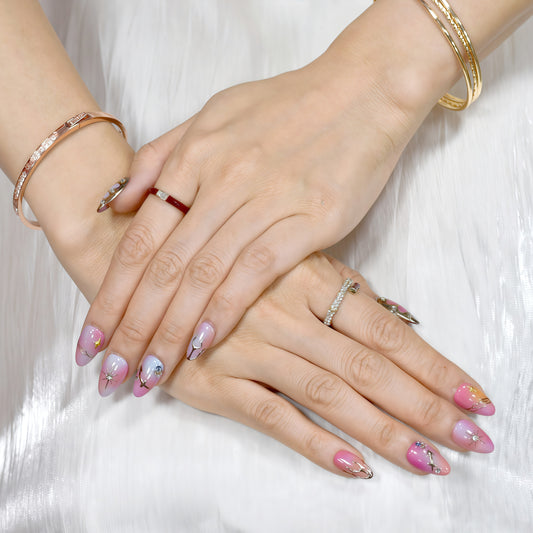 Close-up of hands with pink nail polish and gold jewelry on a white background