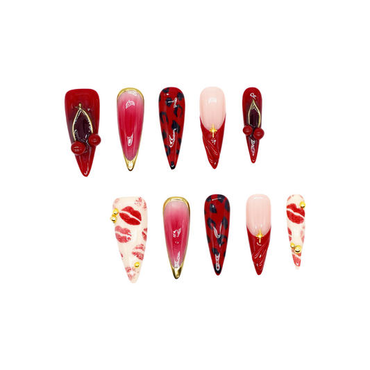 Handmade press-on nails in red, pink, and black with kiss print and cherry accents from You Are Angel.