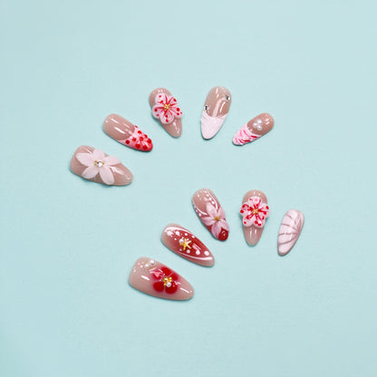 Cherry Bloom press-on nails with red and white flowers, pearl accents, and nude almond shape – handmade by You Are Angel.