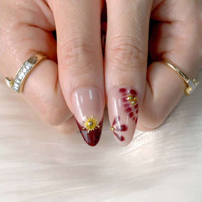 Cherry Mocha Bloom press-on nails featuring mocha brown tones, gold details, and red cherry accents with a glossy handmade finish.