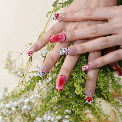 Handmade cherry-red floral press-on nails with glossy ombré finish, cherry accents, and elegant black-and-white artistic nail art