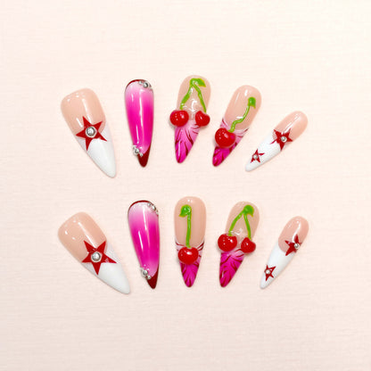 Cherry Pop Star press-on nails featuring pink ombre, 3D cherry accents, and red star details on a glossy nude base.