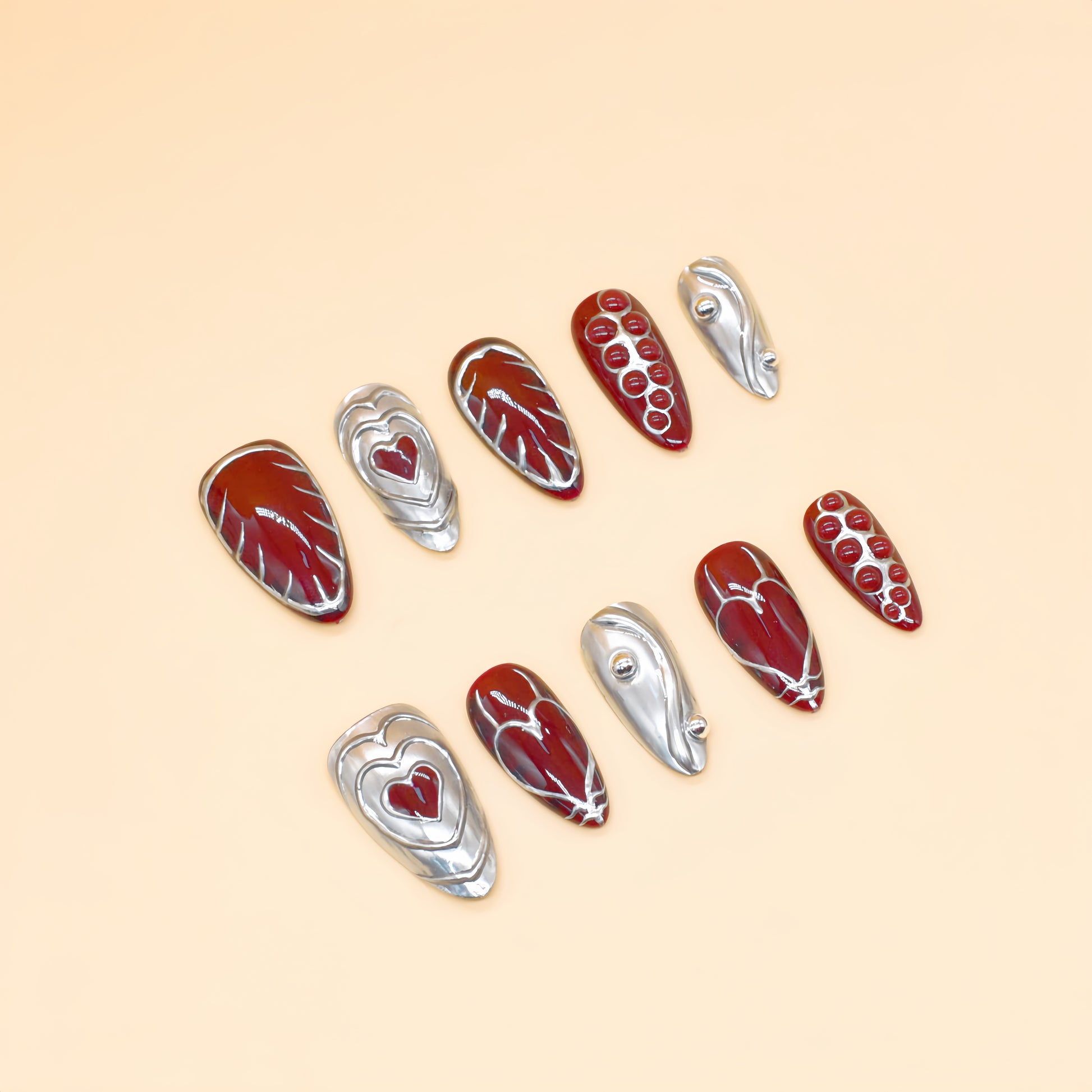 Chrome Heart handmade press-on nails by You Are Angel featuring burgundy base, silver 3D hearts, and sculpted chrome elements.