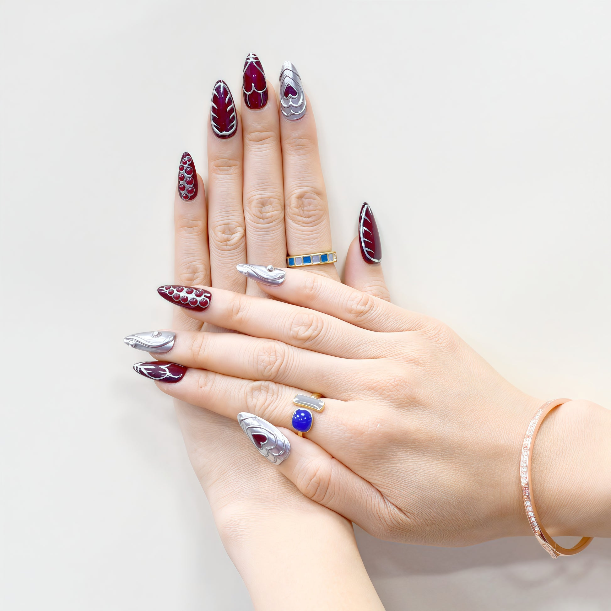 Chrome Heart handmade press-on nails by You Are Angel featuring burgundy base, silver 3D hearts, and sculpted chrome elements.