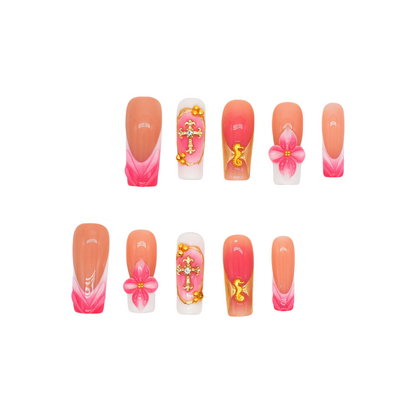 Long square press-on nails featuring coral pink ombre, gold crucifix charms, 3D pink flowers, and golden seahorse details – Coral Bloom Reverie nail set.