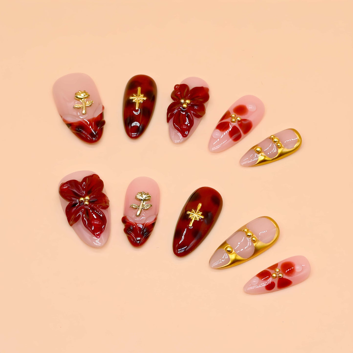 Crimson Bloom press-on nails featuring deep red floral 3D designs, gold details, and glossy pink base for an elegant, romantic look.