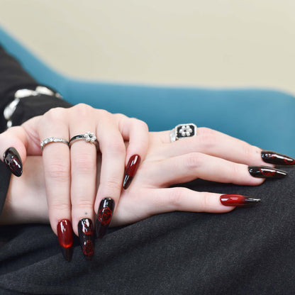 Crimson Shadow press-on nails Crimson Shadow press-on nails featuring black-to-red ombre with hand-painted red roses and glossy finish.