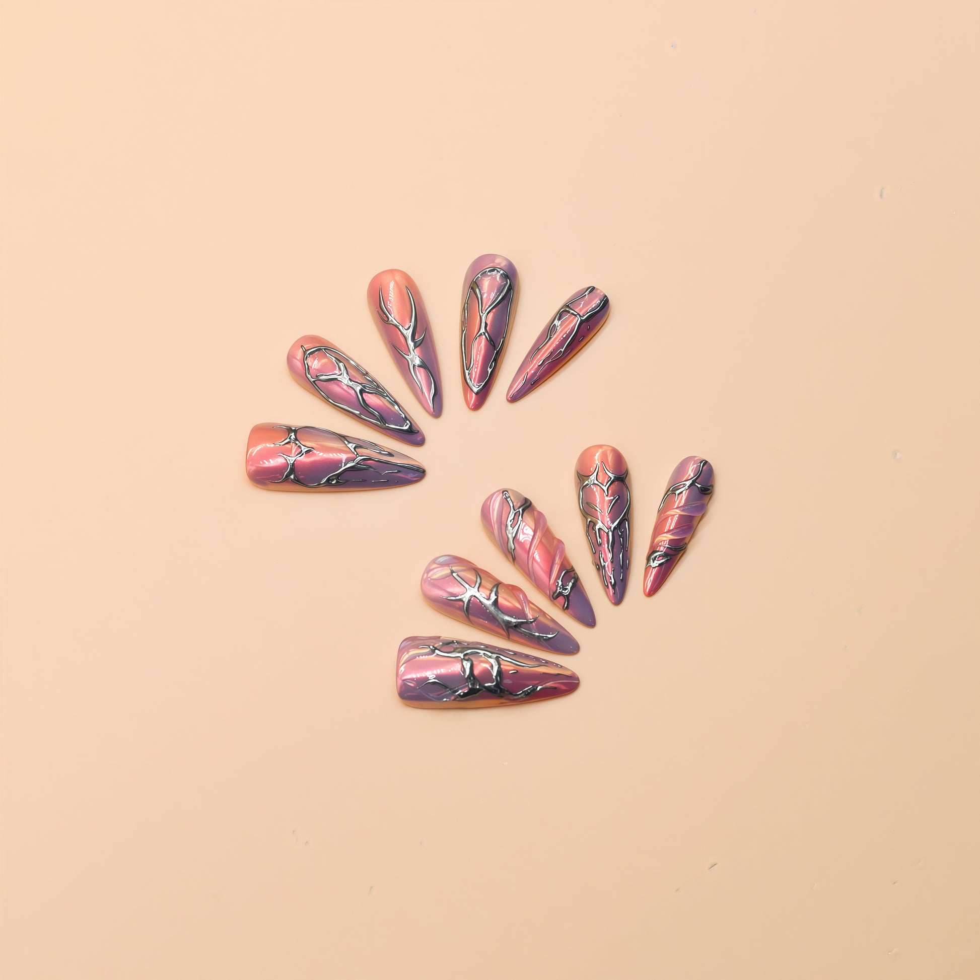 Cyber Crush press-on nails by You Are Angel with pink-purple chrome base and sculpted silver metallic designs in long stiletto shape.