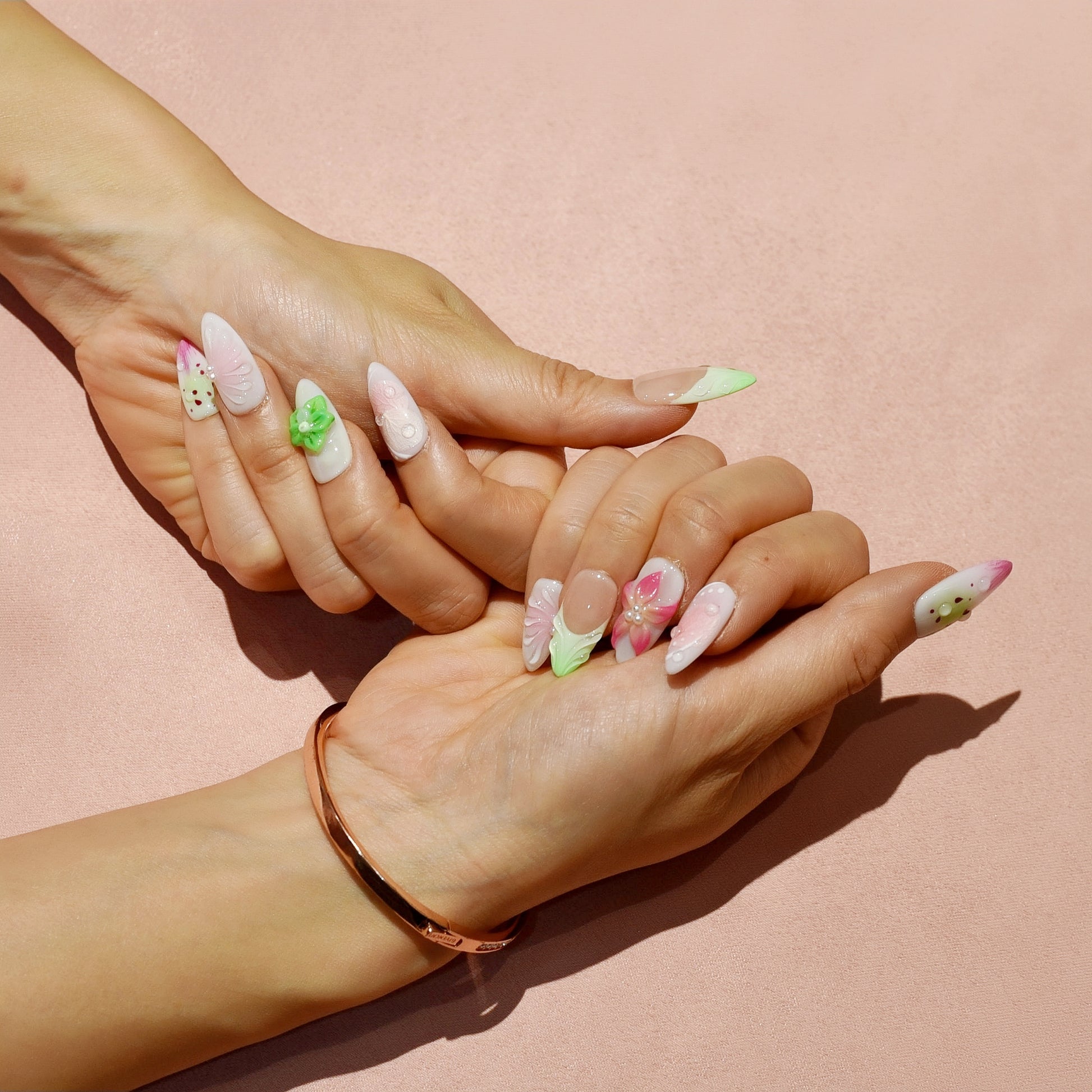 Medium Almond press-on nails with strawberry-seed patterns, green and pink ombré tips, and 3D floral accents in bright green and pink.