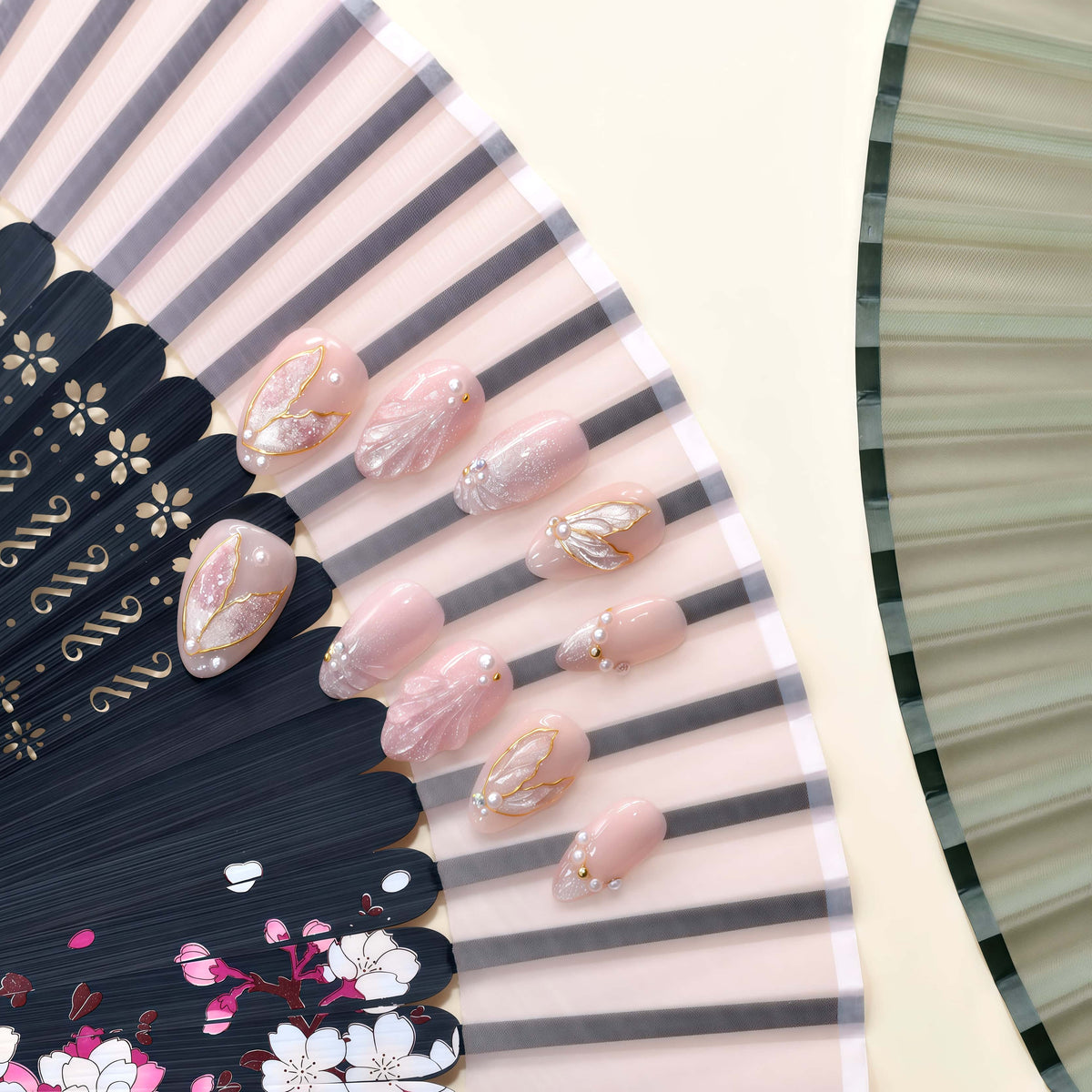 Rose Gold Leaf Veil peach press-on nails with translucent leaves, pearls and fine gold outlines — styled product photograph.