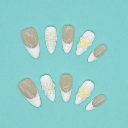 Elegant French tip press on nails with nude base, white tips, and 3D yellow floral accents – Heart & Beat Collection.