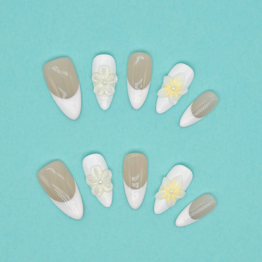 Elegant French tip press on nails with nude base, white tips, and 3D yellow floral accents – Heart & Beat Collection.