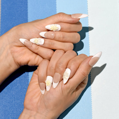 Elegant French tip press on nails with nude base, white tips, and 3D yellow floral accents – Heart & Beat Collection.