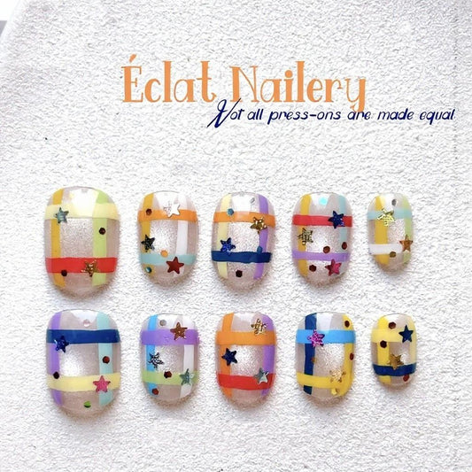 Handmade press-on nails featuring colorful rainbow grid patterns with a glossy finish, designed for playful, bold expression.